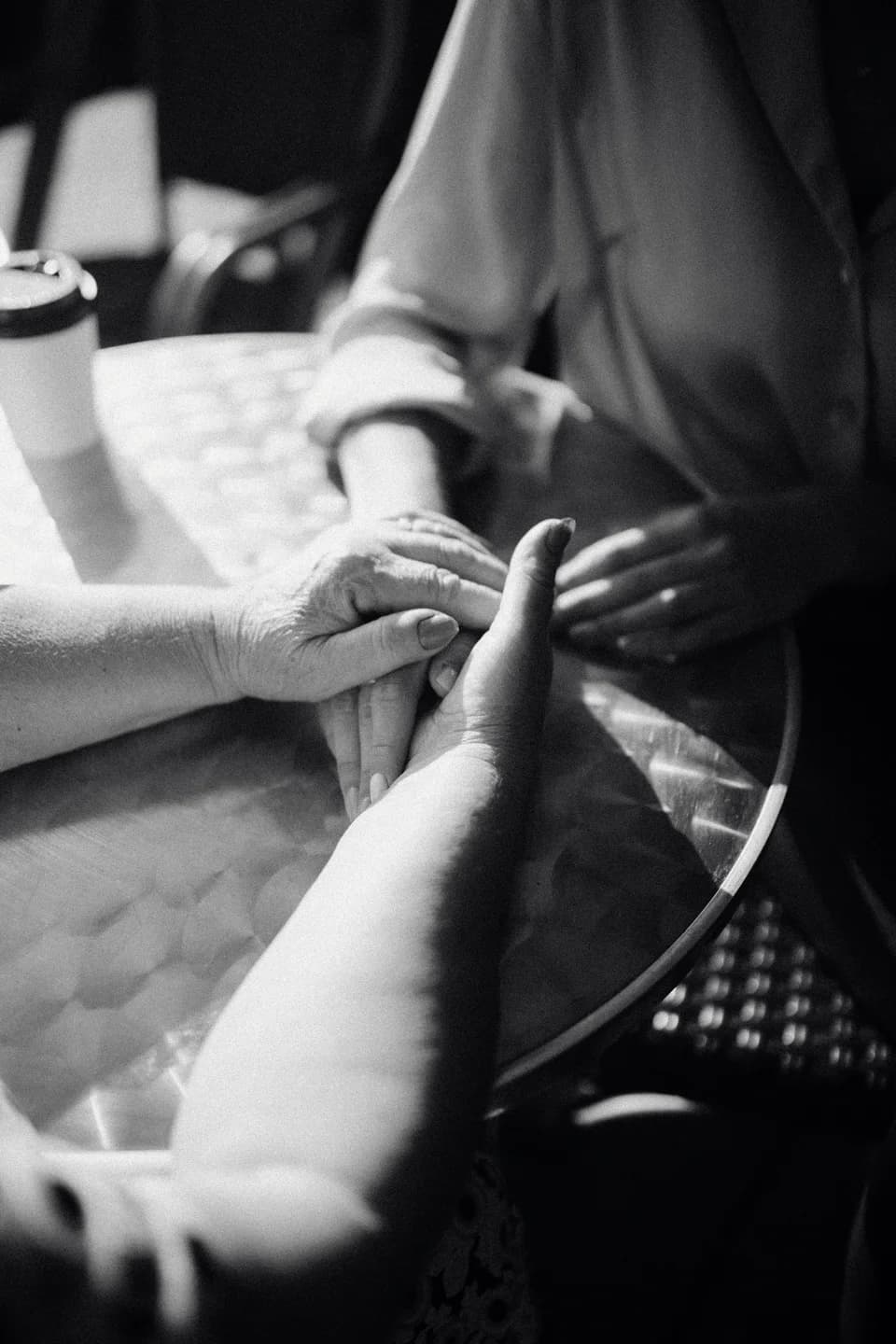 Two people holding hands across a table
